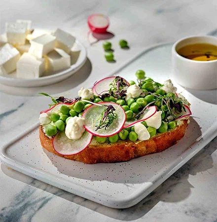 Бутерброд с мягким сыром в рассоле и творожным сыром, с молодым горошком и редисом