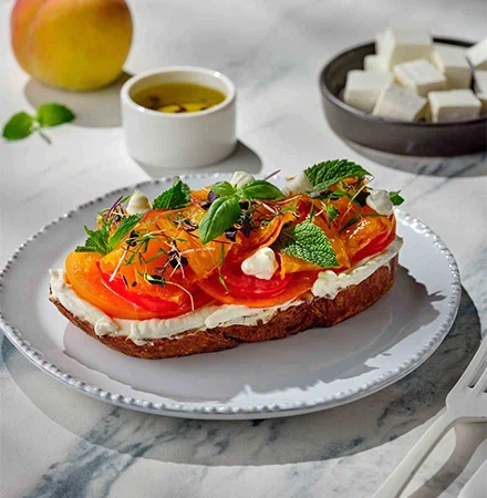 Бутерброд с мягким сыром в рассоле и творожным сыром, разноцветными томатами, персиками